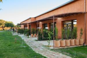 a building with potted plants on the side of it at Trafalgar Polo Club in El Palmar