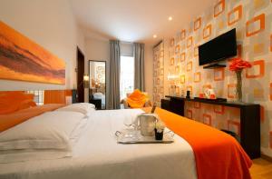 una camera con letto bianco e TV a schermo piatto di Hotel De La Pace, Sure Hotel Collection by Best Western a Firenze