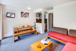 a living room with a couch and a table at Vacancéole - Le Privilège in Germ