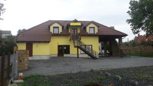 una casa gialla con una scala di fronte di Penzion AMÁLKA Černín a Zdice