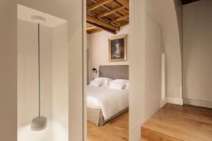 a bedroom with a white bed and a mirror at Crossing Condotti in Rome