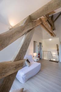 a living room with a white couch and wooden beams at Le Domaine de Mandrin in Madranges