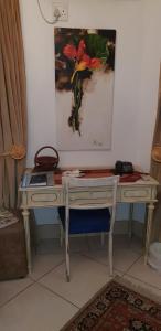 a desk in a room with a painting on the wall at Kleineweide Boutique Estate in Pretoria