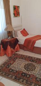 a bedroom with a bed and a table with a rug at Kleineweide Boutique Estate in Pretoria