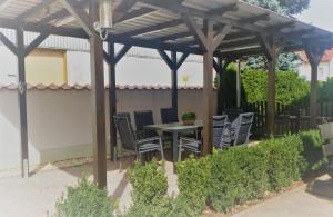 eine hölzerne Pergola mit einem Tisch und Stühlen darunter in der Unterkunft Ferienwohnung "Burgblick" in Heldrungen