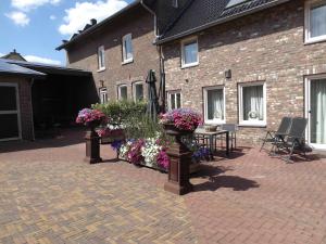 a patio with flowers and a table in front of a building at De Moolt Vakantiewoningen in Eckelrade