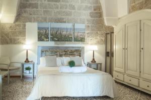 a bedroom with a large white bed with two pillows at B&B Aurora Salentina in Morciano di Leuca