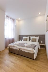 1 dormitorio con 1 cama grande y suelo de madera en Debo Apartments nähe Westbahnhof - contactless check in, en Viena