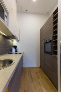 a kitchen with wooden cabinets and a sink at Debo Apartments nähe Westbahnhof - contactless check in in Vienna