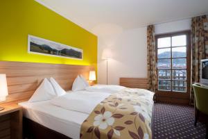 Habitación de hotel con cama y TV en Alphotel Innsbruck en Innsbruck