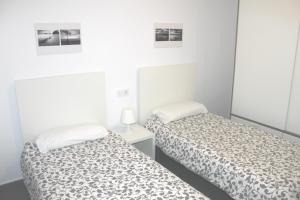 2 Betten in einem Zimmer mit weißen Wänden in der Unterkunft Apartamento Gaviotas in Tarifa