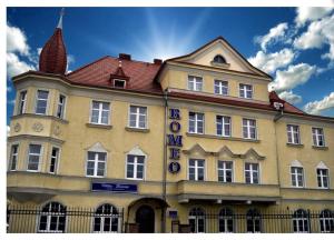 a large yellow building with a sign on it at Villa Romeo in Brzeg