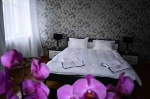 um quarto com uma cama com flores roxas no primeiro plano em Villa Romeo em Brzeg