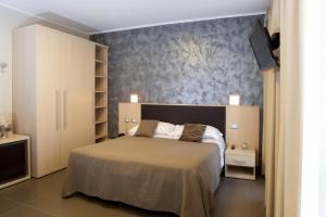 une chambre avec un lit et une télévision sur un mur dans l'établissement Villa Gioiosa, à Diano Marina