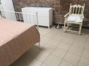 a bedroom with a bed and a dresser and two chairs at B&B Juighissa Leonora in Oristano