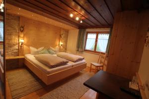 een slaapkamer met een bed in een houten kamer bij Hotel Maroi in Wald am Arlberg
