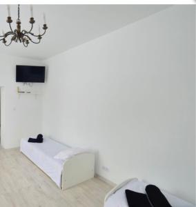 Habitación blanca con cama y lámpara de araña. en Villa Romeo, en Brzeg