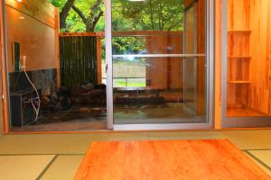 an empty room with a sliding glass door and a table at Seiryuso in Misasa