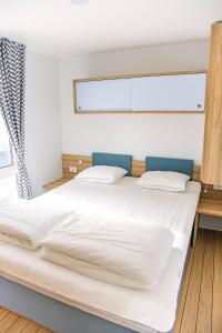 1 cama blanca grande en una habitación con ventana en Vännäs bad & camping, en Vännäs