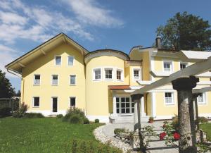 une grande maison jaune avec une cour dans l'établissement Haus Hildegunde, à Bad Füssing