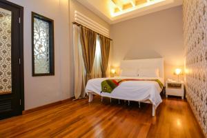een slaapkamer met een wit bed en een raam bij Jonker Boutique Hotel in Melaka