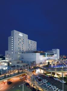 Hotel Associa Toyohashi في تويوهاشي: مبنى كبير به سيارات تقف في موقف للسيارات