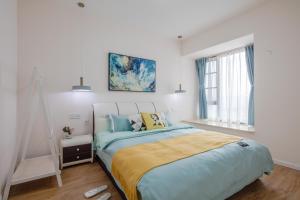 um quarto branco com uma cama grande e lençóis azuis em ChengDu JinNiu·ChunXi Road Locals Apartment 00129440 em Chengdu