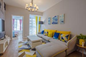 uma sala de estar com um sofá e almofadas amarelas e azuis em ChengDu JinNiu·ChunXi Road Locals Apartment 00129440 em Chengdu