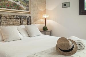 Un dormitorio con una cama con un sombrero de paja. en B&B Aurora Salentina, en Morciano di Leuca