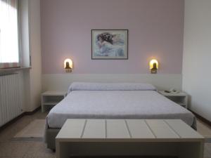 sypialnia z łóżkiem, dwoma stołami i dwoma światłami w obiekcie Hotel O'Scugnizzo 2 w mieście Belluno