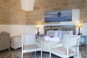 a room with a table and two chairs and a bed at B&B Aurora Salentina in Morciano di Leuca