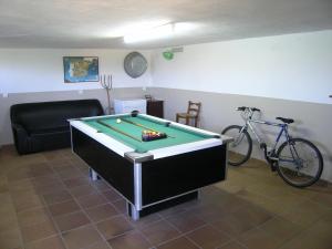 sala de estar con mesa de billar y bicicleta en La Casita de Piedra, en Ronda