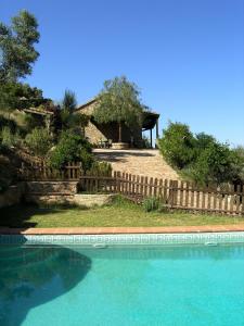 uma piscina em frente a uma casa com uma cerca em La Casita de Piedra em Ronda