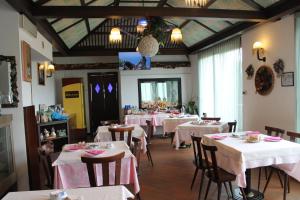 ein Esszimmer mit Tischen und Stühlen sowie weißen Tischdecken in der Unterkunft Hotel O'Scugnizzo 2 in Belluno