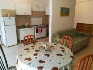 cocina y sala de estar con mesa y sofá en Appartamento a Villapiana Lido, en Villapiana