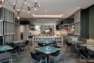 a restaurant with tables and chairs and a bar at Fraser Place Setiabudi Jakarta in Jakarta