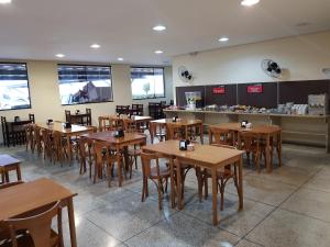 a restaurant with wooden tables and chairs and a counter at Hotel Gran Valle in Registro