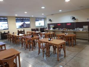 un restaurant avec des tables et des chaises en bois et un comptoir dans l'établissement Hotel Gran Valle, à Registro