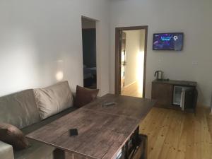 a living room with a couch and a wooden table at Emerald House Gabala in Gabala