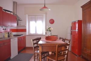 Il comprend une cuisine équipée d'une table et d'un réfrigérateur rouge. dans l'établissement Casa la Terrazza sul Lago - WelcHome, à Cannobio