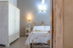 a bedroom with a white bed and a white dresser at Le torri di Tarquinia in Tarquinia
