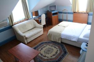 a bedroom with a bed and a couch and a table at Hotel Tomce Sofka in Skopje
