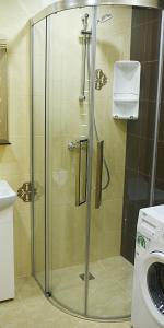 y baño con ducha y puerta de cristal. en Apartments Victoria, en Panevėžys