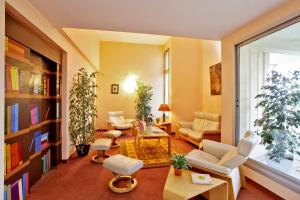 a living room with white furniture and a large window at L'Aquitaine - Cahors Sud in LʼHospitalet