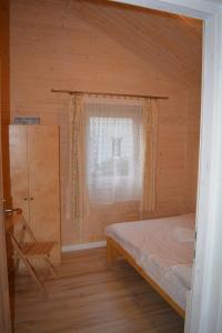 um quarto com uma cama, uma janela e uma cadeira em RÓŻANY ZAKĄTEK em Zełwągi