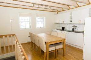 a kitchen and dining room with a wooden table and chairs at Tjeldsundbrua Maritim in Evenskjer