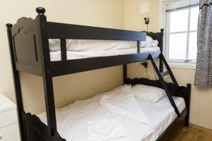 a bedroom with two bunk beds in a room at Tjeldsundbrua Maritim in Evenskjer