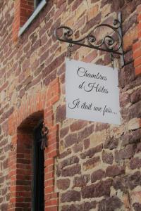 a sign on the side of a brick wall at Il était une fois Brocéliande in Saint-Malon-sur-Mel