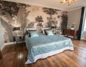 a bedroom with a bed with a painting on the wall at Hostellerie La Montagne in Colombey-les-deux-Églises