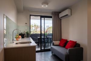 a kitchen and a living room with a couch and a table at Ascot Budget Inn & Residences in Brisbane